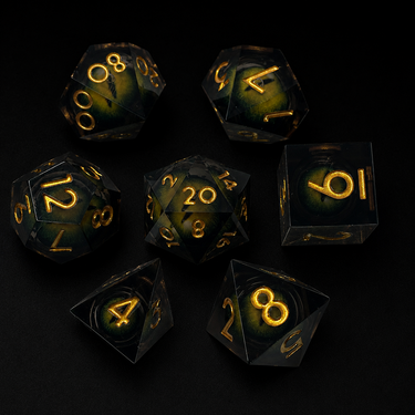 Set of black polyhedral dice with gold numbering on a dark background
